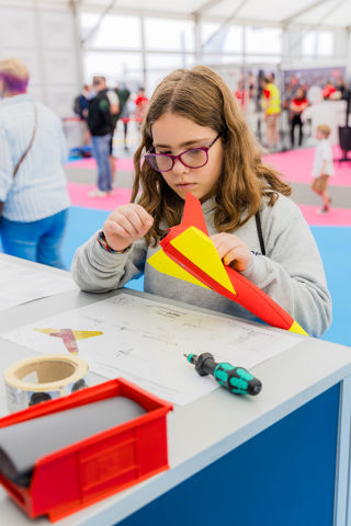 A girl building a foam aircraft in the Techno Zone at RIAT25.