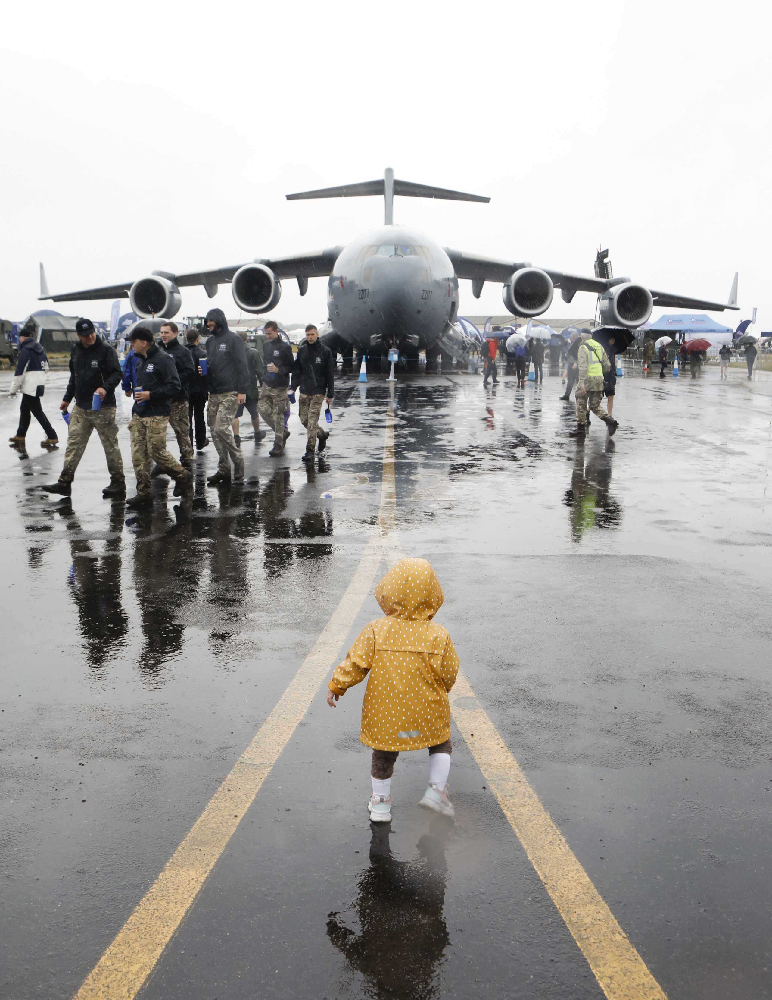 Toddler in front of aircraft in the rain at RIAT23