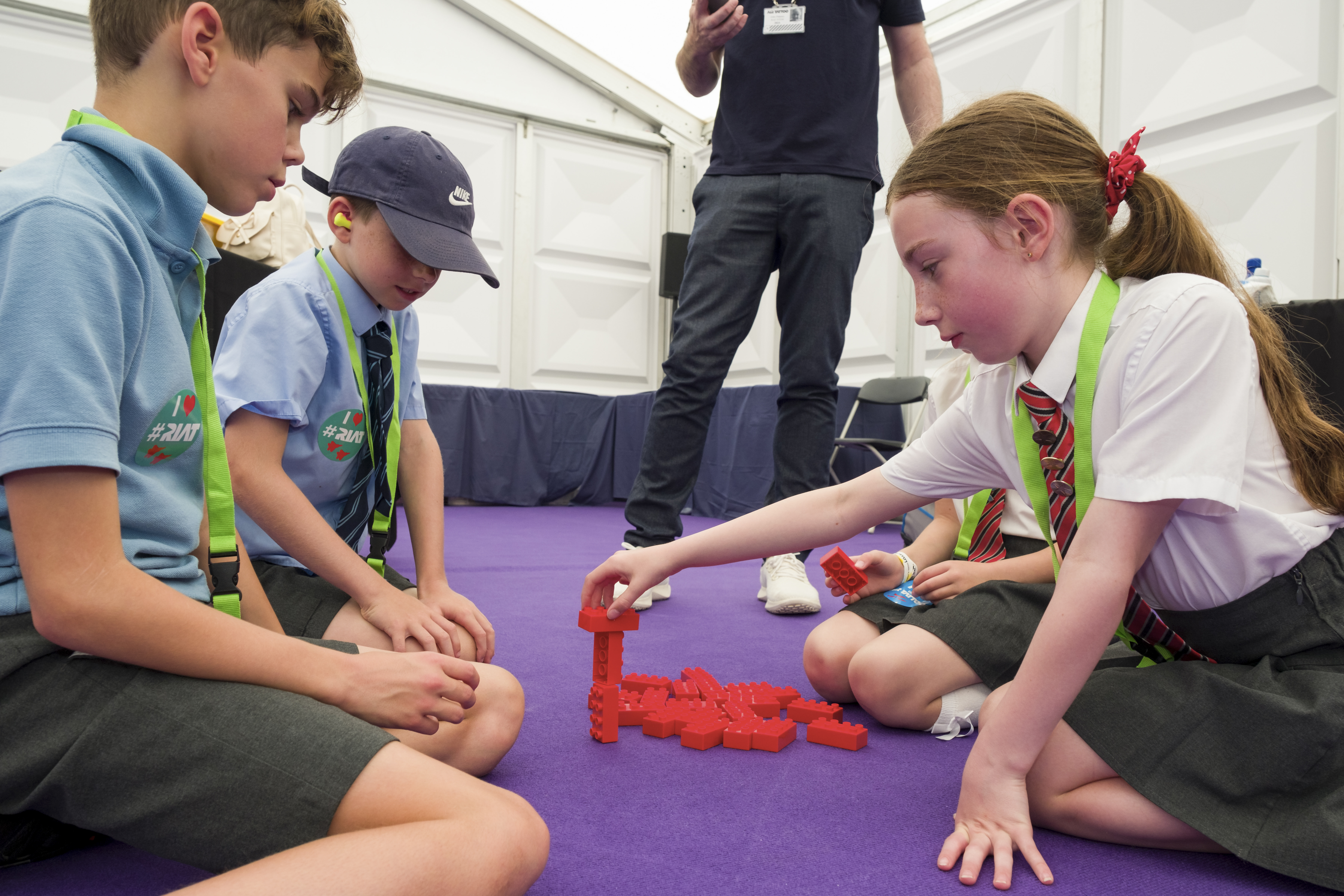 A girl and two boys in an activity with Lego bricks at Road to RIAT at RIAT24