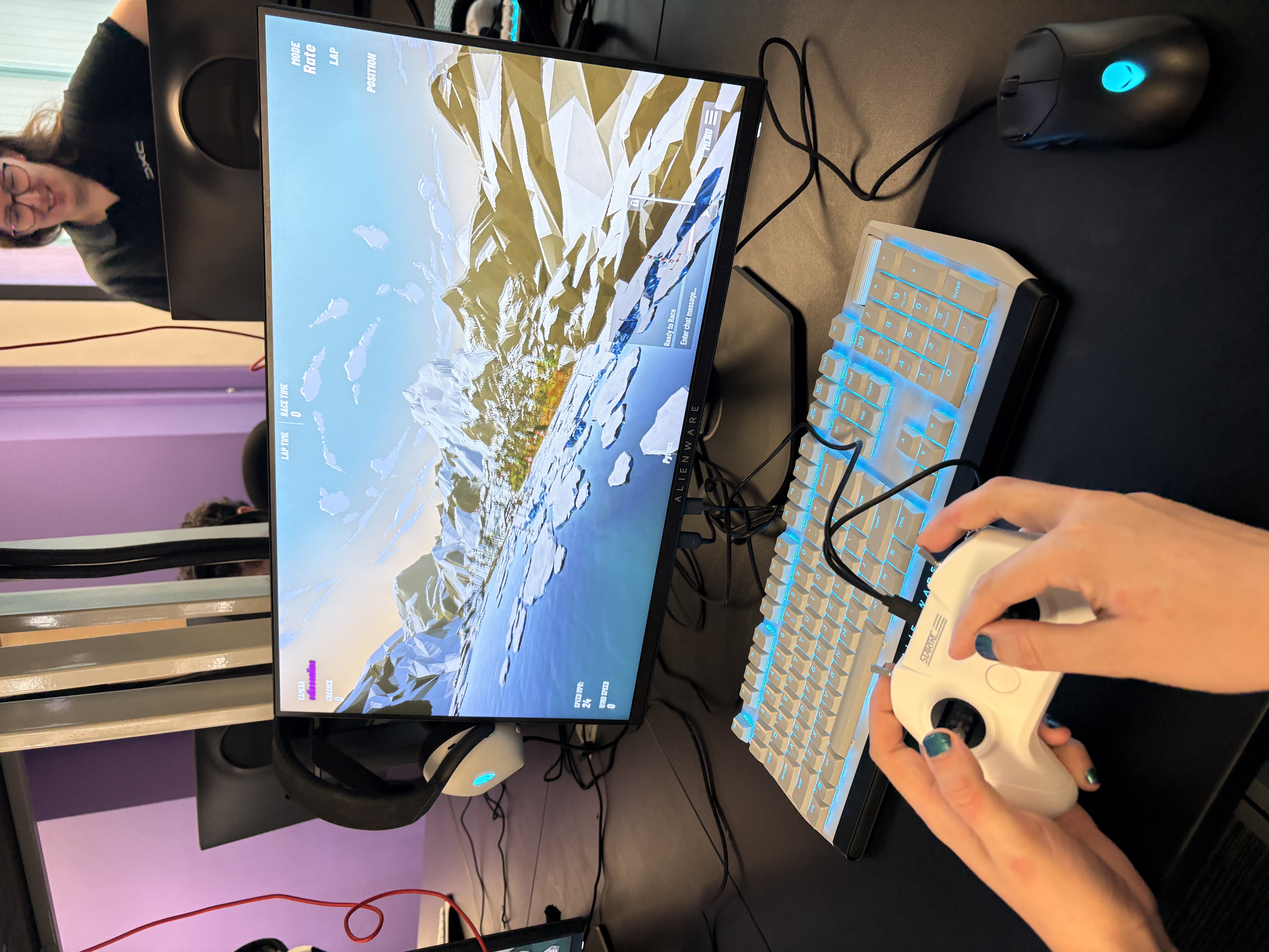 RACE to RIAT gaming screen with girl's hands and keyboard.