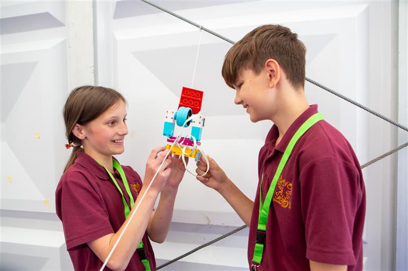 Pupils taking part in a Road to RIAT Blast Off activity with a model on a pulley
